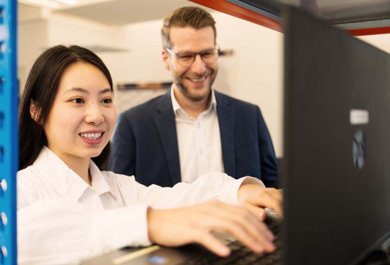 Zwei Mitarbeitende arbeiten am Laptop