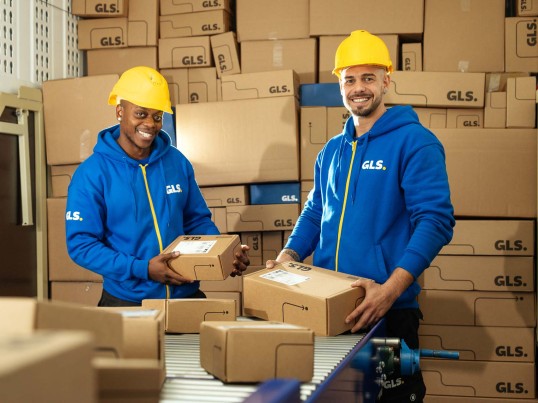 Two employees shake hands in the warehouse