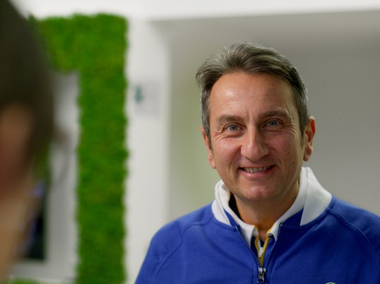 A GLS employee stands in the parcel shop and smiles at the camera