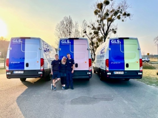 Employees stand in front of GLS Sprinters